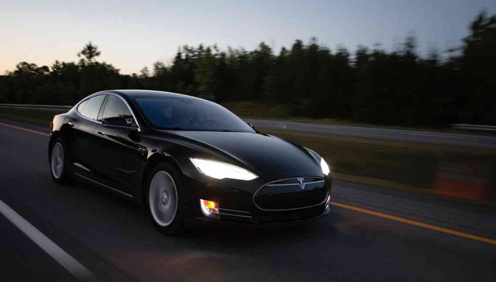 Black Tesla Model S driving on a highway