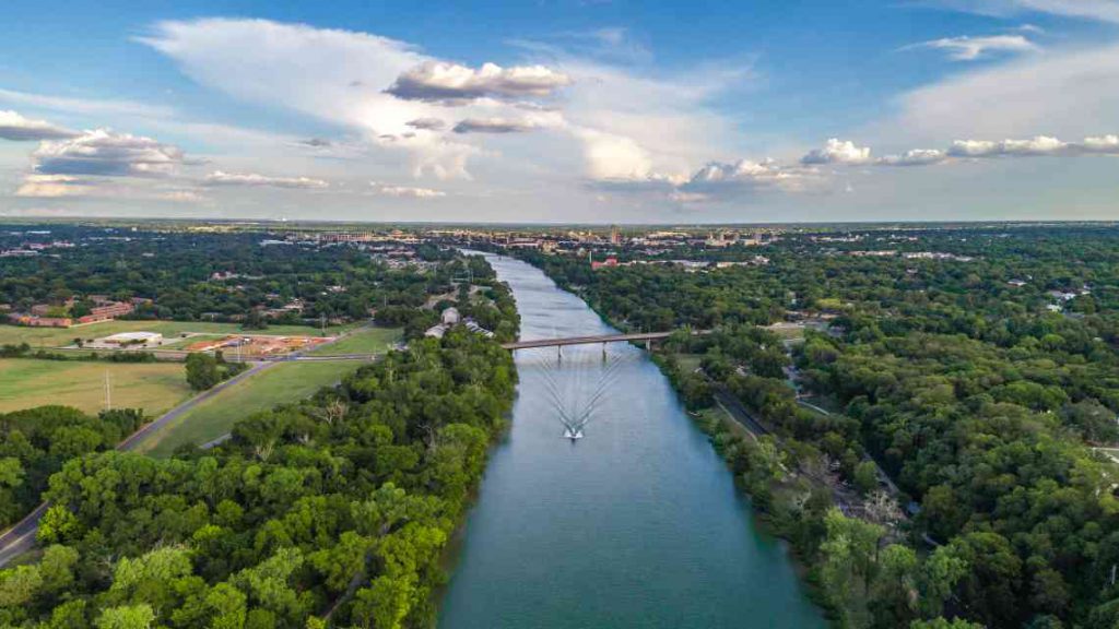 Wide river with leafy trees flowing through Waco, Texas