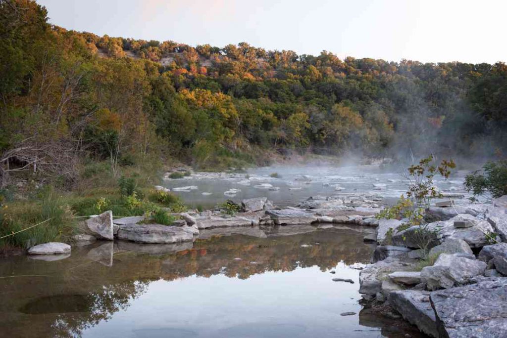 PaluxyRiver with rocks surrounced by trees with multicolored leaves.