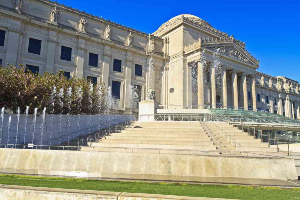 Romanesque exterior of the Brooklyn Museum and its fountain.
