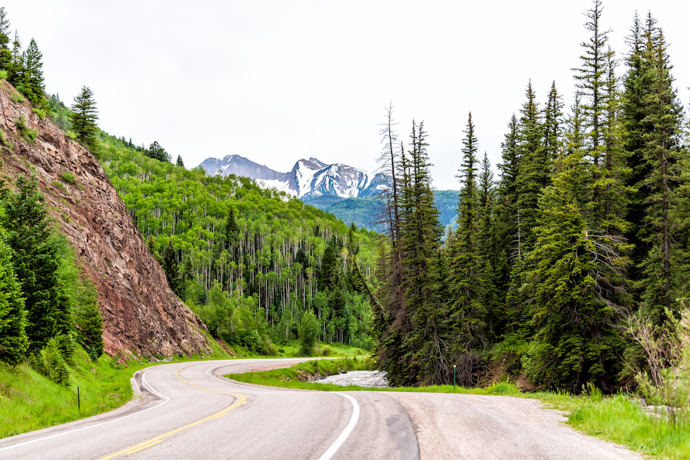 Road highway 133 in Redstone, Colorado during summer with empty street, snow mountain peak and green trees | Glamping Destination | SIXT