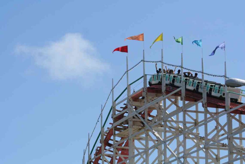 White wooden roller coaster with flags at the top