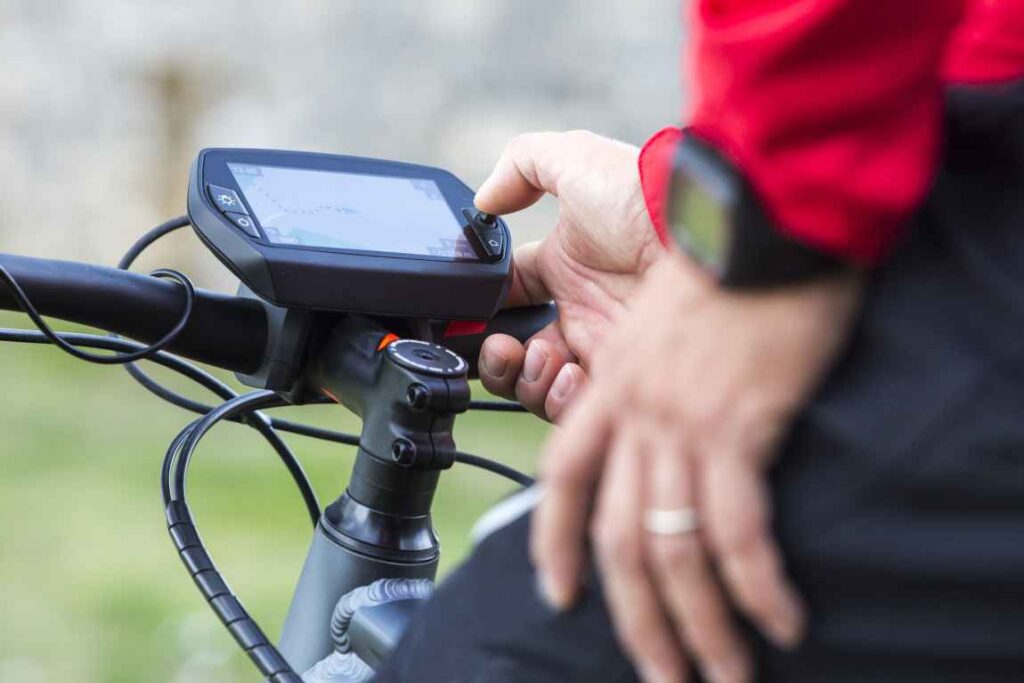 Person pressing a button on a bike navigation computer