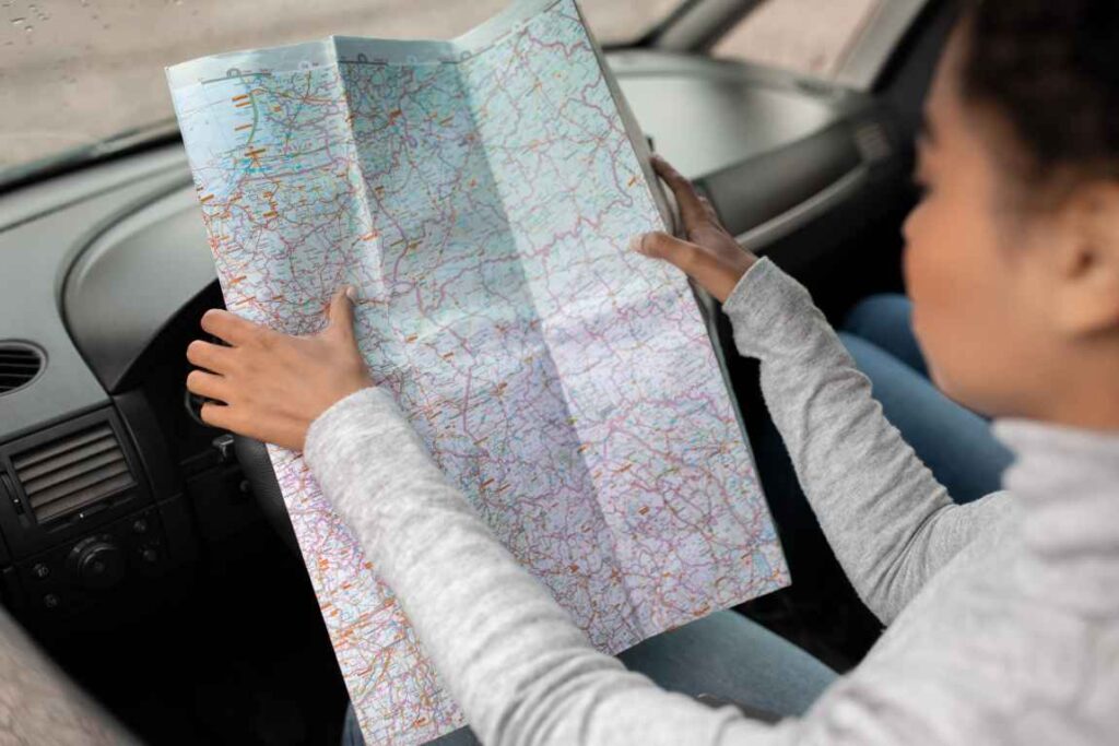 Woman looking at a paper map in a car