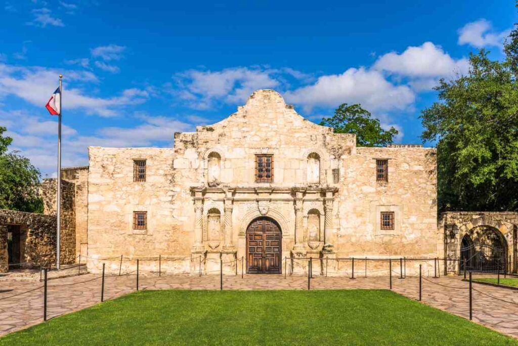 Alamo in sunshine with flag flying in front