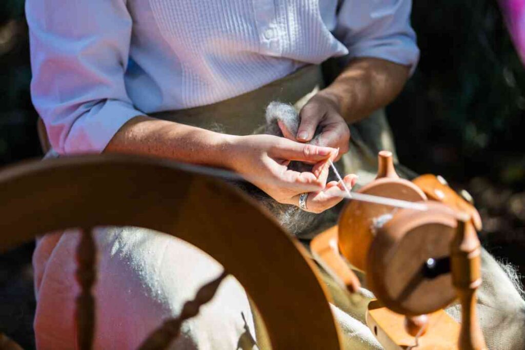 woman in white shirt in front of spinning wheel