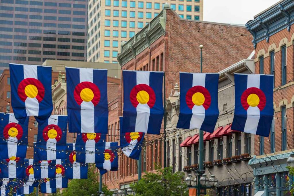 blue and white striped flags hanging among buildings in Denver