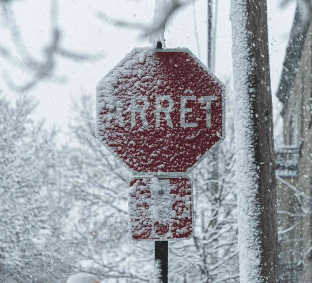 Stop sign in French, covered in snow