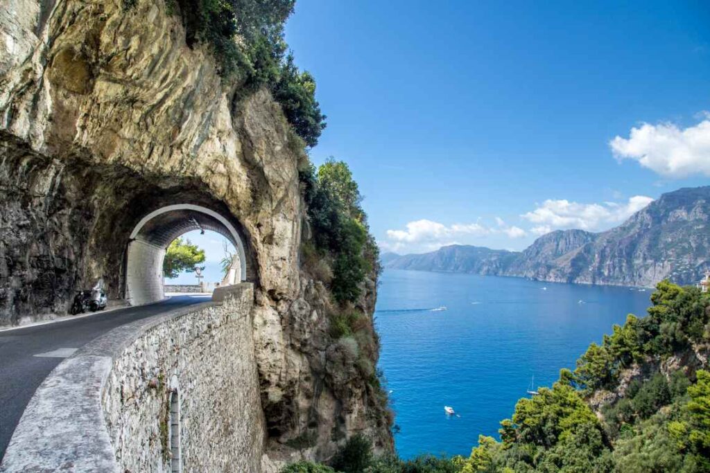 narrow tunnel through rock high above the water of the Amalfi Coast