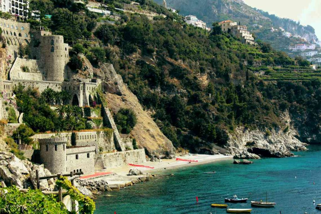 a beach and medieval buildings in conca dei marini