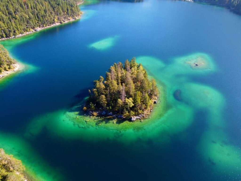 small island with pine trees in Dark blue and green waters