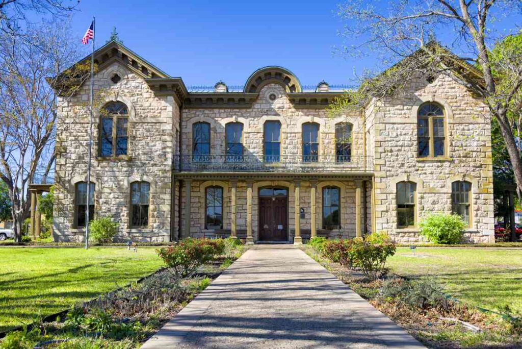 historic limestone building with american flag on flagpole in front