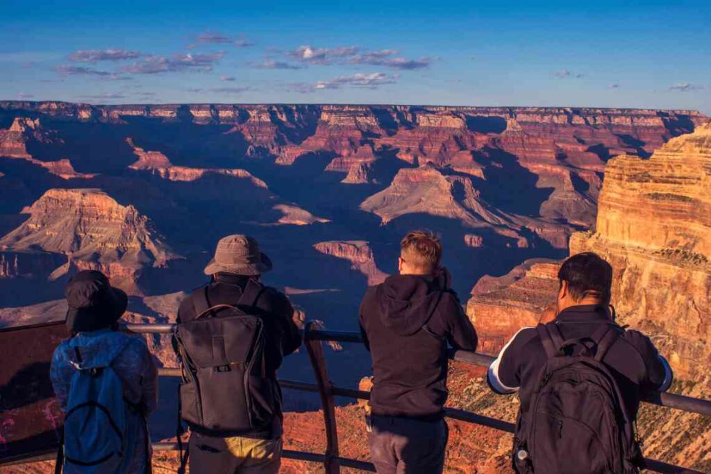 People taking photos from mojave point at the grand canyon at sunset