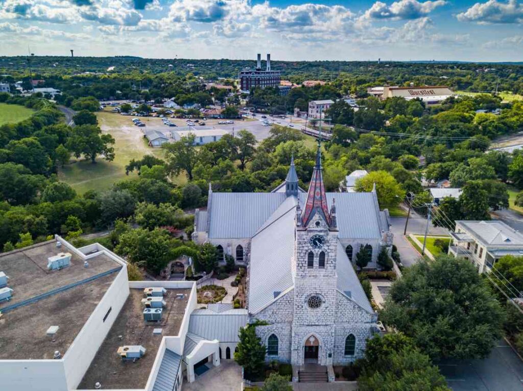 historic stone church and drone view of new braunfels, texas