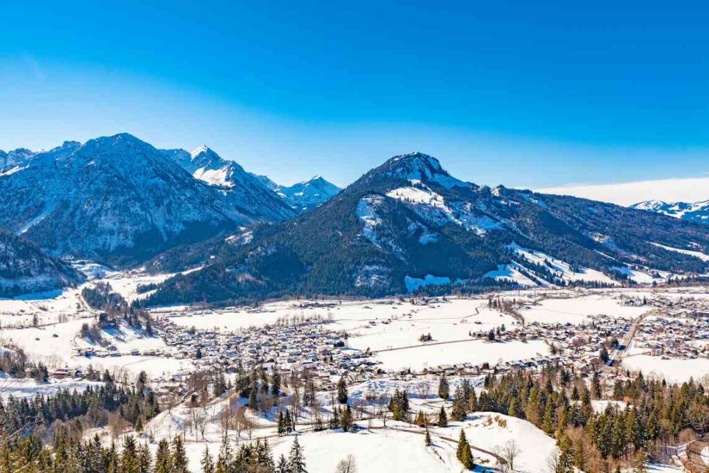 snow covered mountains with a valley and houses