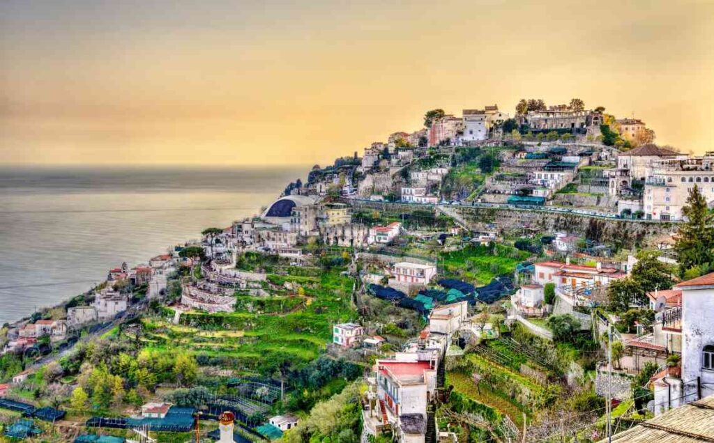 houses and buildings built on terraced earth rising from the ocean