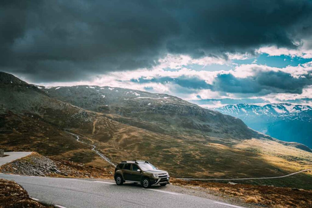 brown SUV in front of mountain landscape