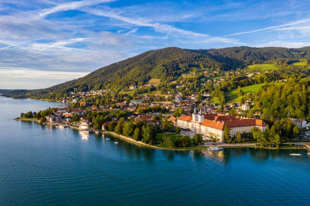 blue alpine lake with German town and mountains rising from the banks