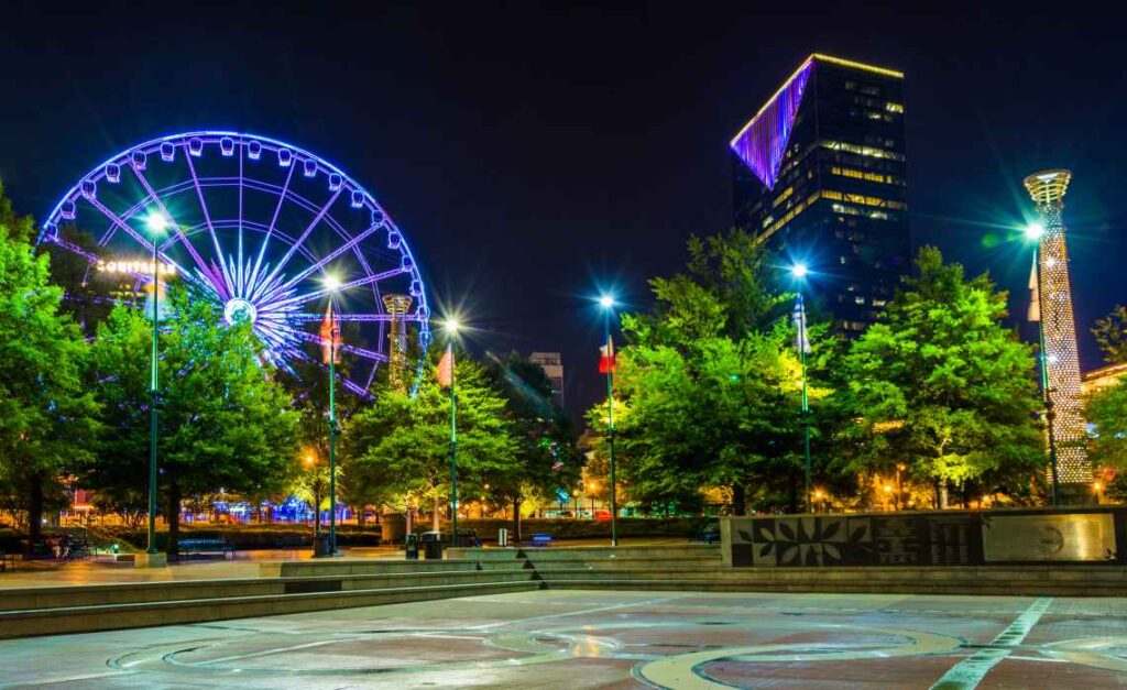 ferris wheel lit with purple lights in the dark in atlanta's olympic centennial park