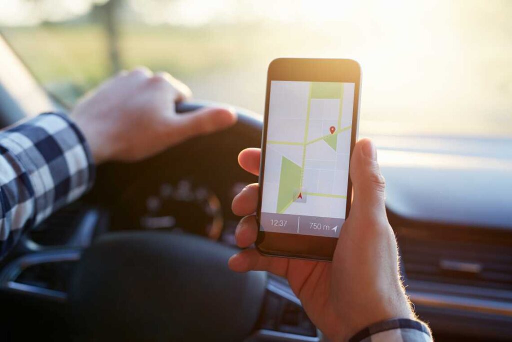 Man holding photo with map navigation in front of the steering wheel