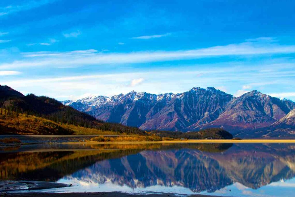 snow capped mountains reflected in kluane lake in canada's yukon