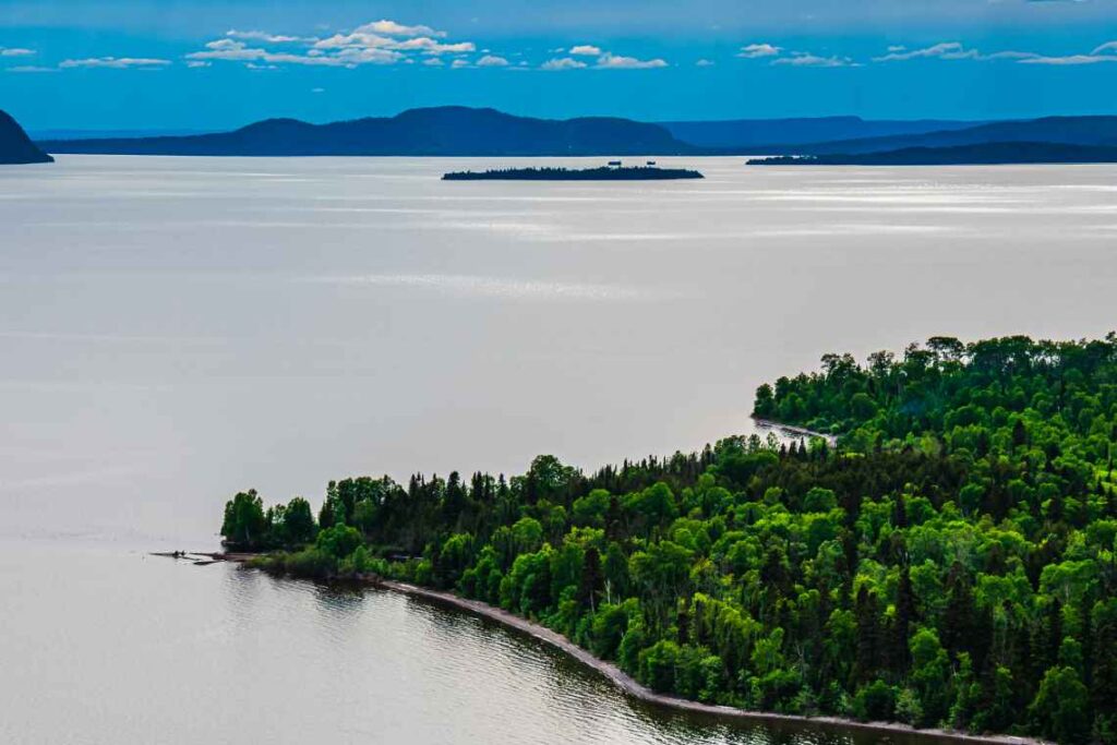 shoreline of lake superior with green forest and islands