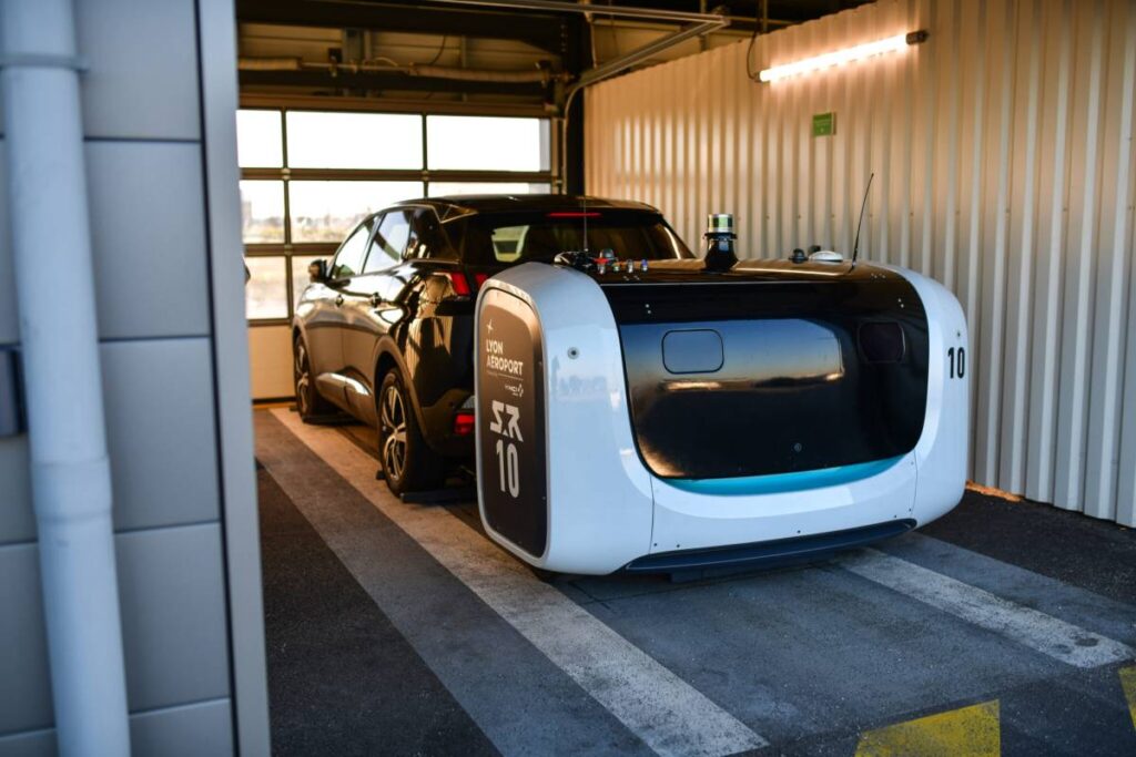 small black SUV being parked with an autonomous robot at lyon airport in france