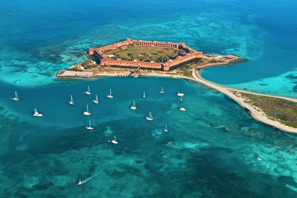 fort jefferson in tortugas national park surrounded by sailboats and turquoise water