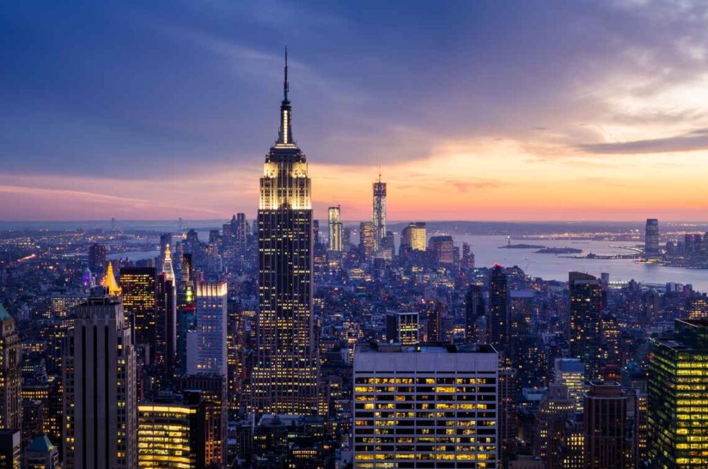 Empire state building with the lights on at sunset