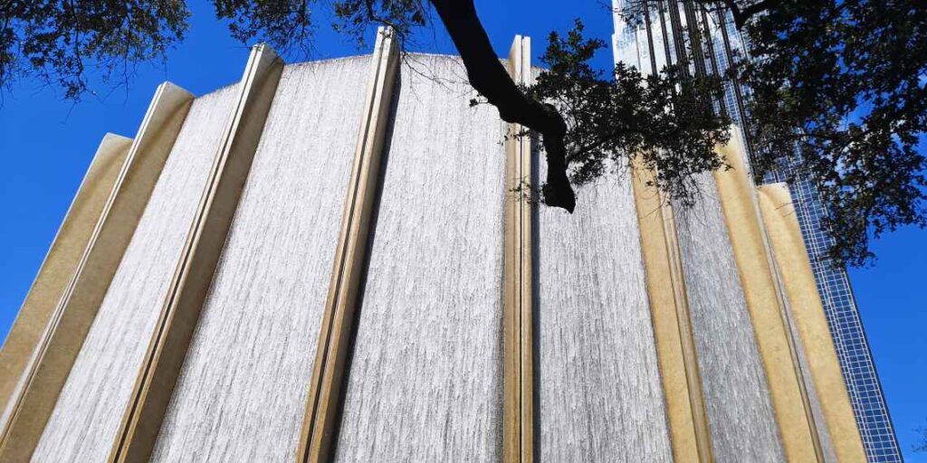 sculpture with cascading water against a blue sky