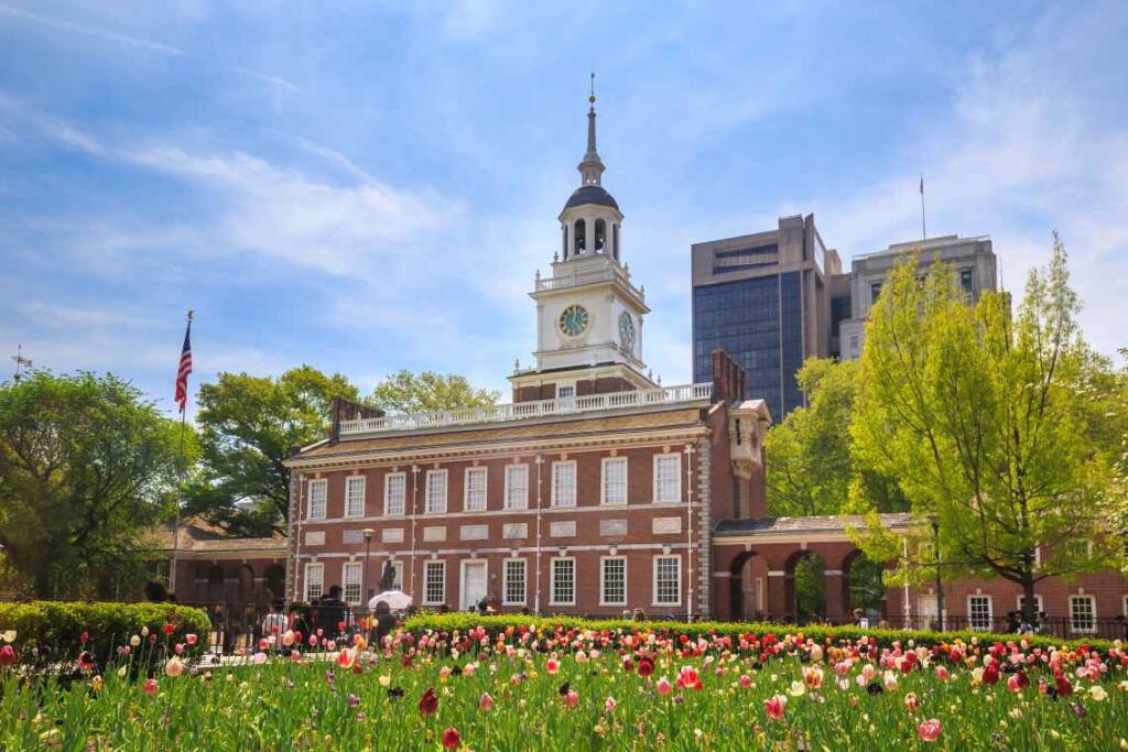 a field of tulips in front of of red brick and white independence hall in philadelphia