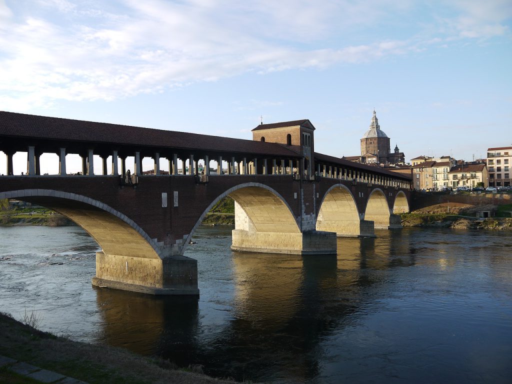 covered stone bridge over a river in pavia