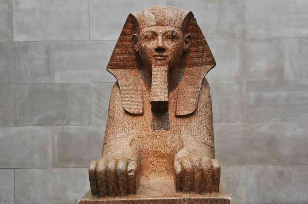 close up of stone egyptian sphinx with gray stone background