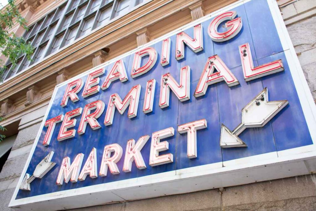 blue sign with reading terminal market in white with red neon