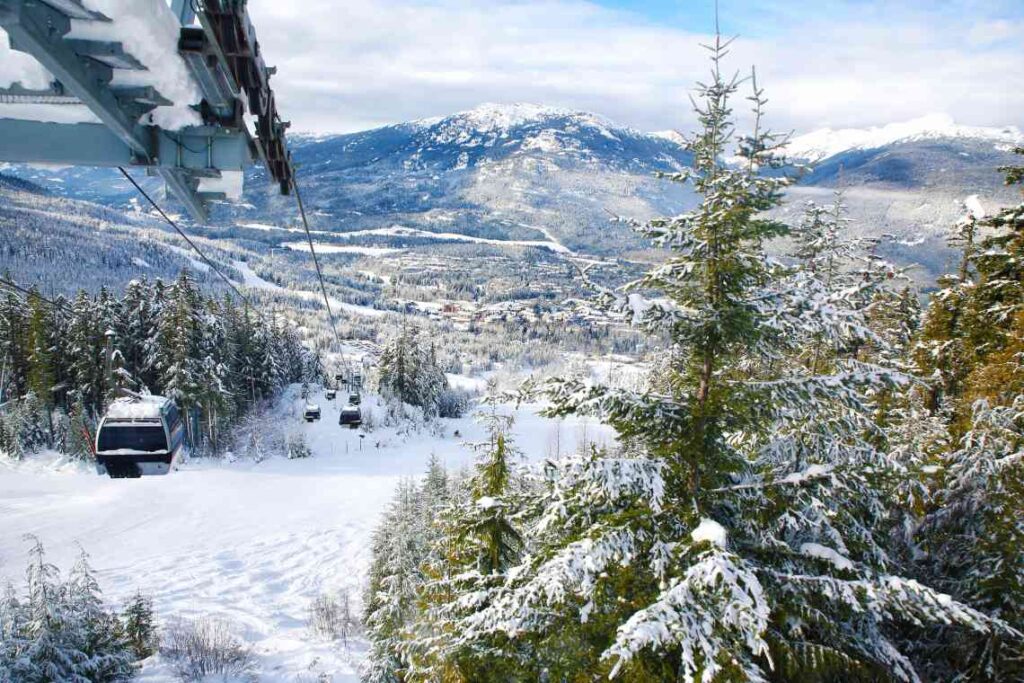 ski lift from whistler-blackcomb village with pine trees and mountains in the background