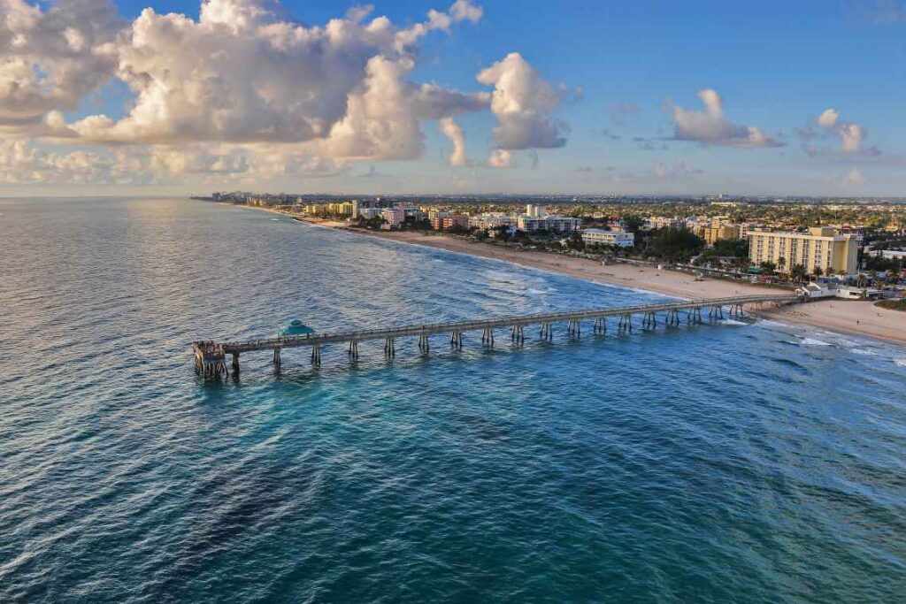 long wooden pier going into the blue ocean from dania beach in south florida