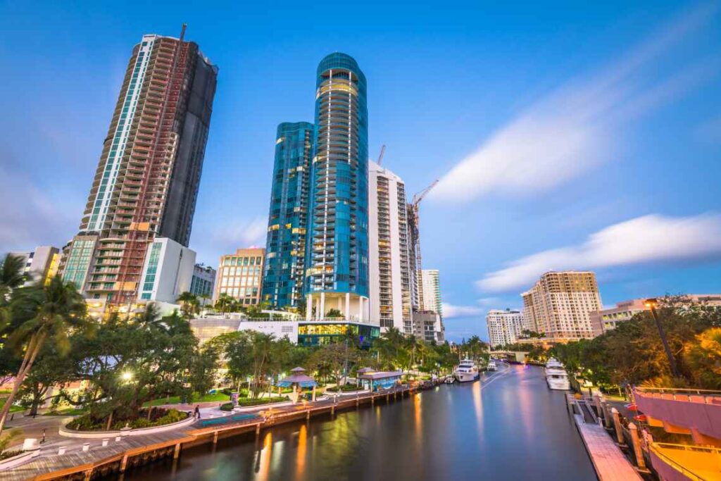 river in fort lauderdale with a walkway on one side and skyscrapers