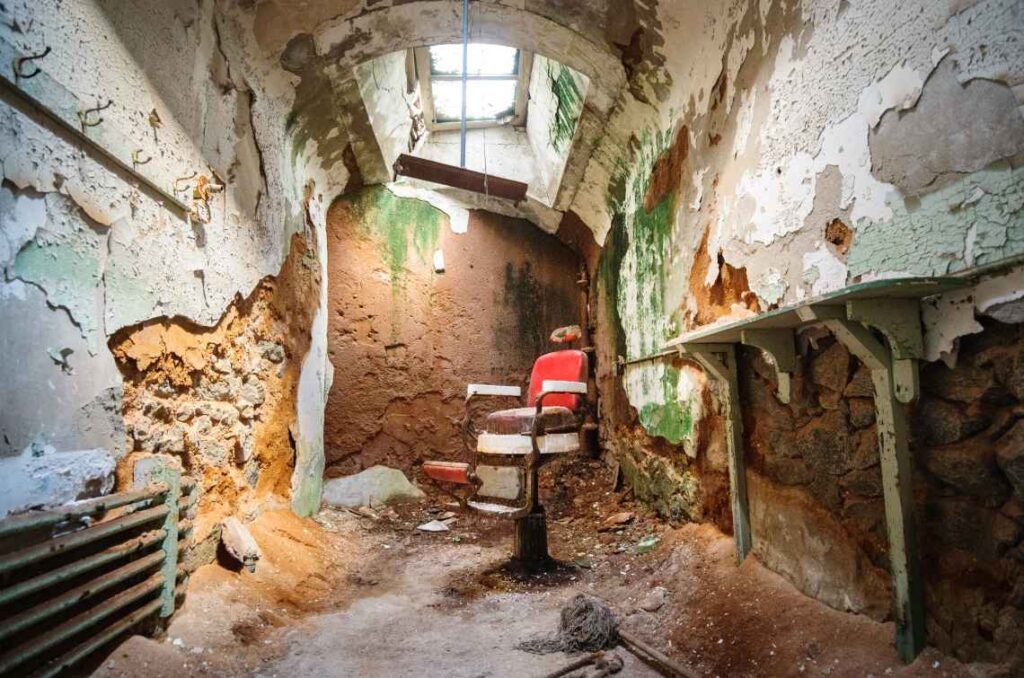 crumbling walls and a room with red barber chair with a skylight above