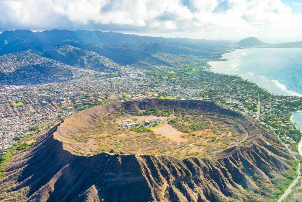 aerial view of large dormant volcano Diamond Head crater on oahu with honolulu below