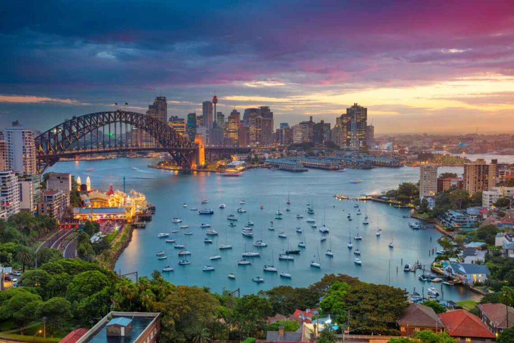 sydney harbor with ships and the harbor bridge, with the sydney australia skyline in the background