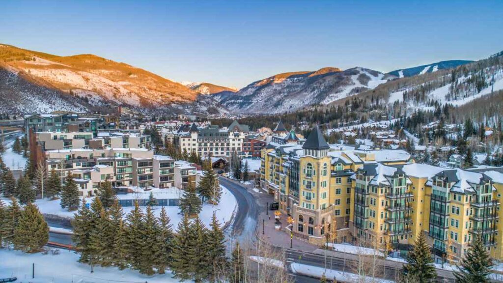 buildings of Vail Village from above on a sunny winter day with mountains in the background