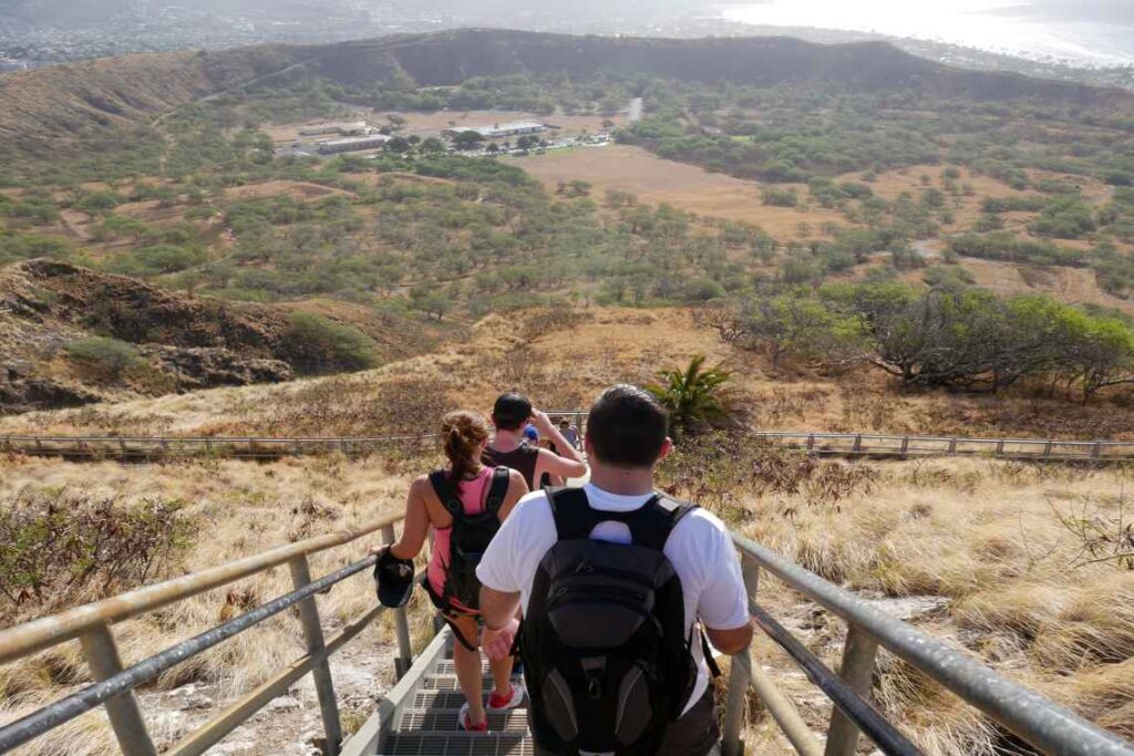 Group of people walking down metal stairs into the Diamond Head crater in hawaii