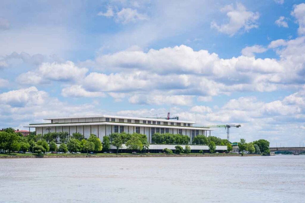 white exterior of the john f. kennedy center of performing arts sitting on the water