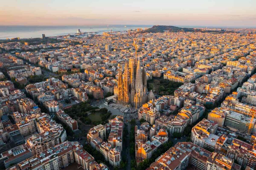 overhead cityscape shot of barcelona, spain at sunset with sagrada familia in the center