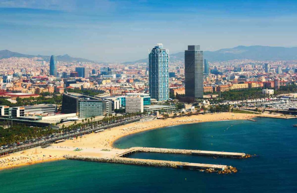overhead shot of long beach in barcelona spain with skyscrapers and cityscape in the background