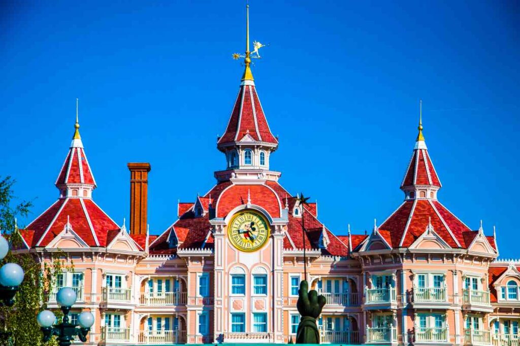 The pink outside of the disneyland hotel with a mickey mouse clock at the disneyland resort in paris