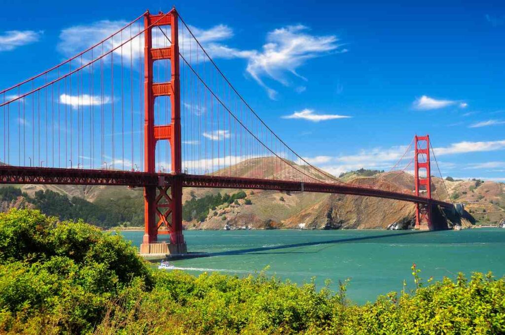 red suspension golden gate bridge on a sunny day above turquoise water