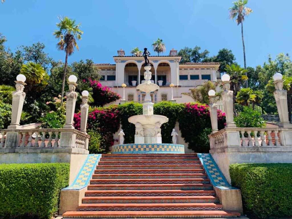 stairs and a fountain leading up to the white hearst castle in northern california
