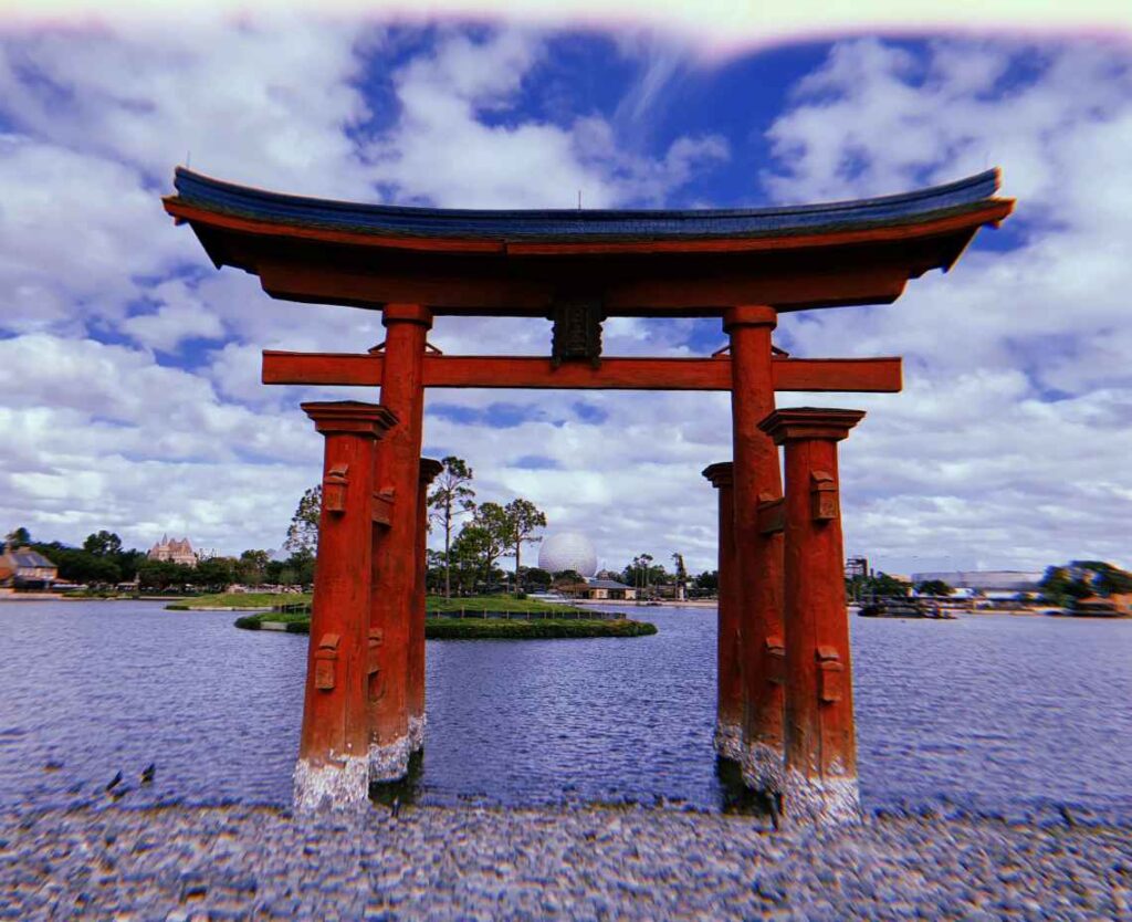 red japanese structure on a pond with epcot center in the background