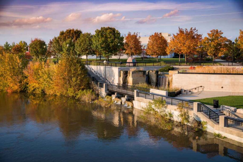 A promenade with trees in fall along the river running by White River State Park in Indianapolis